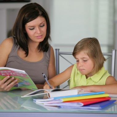 Portrait d'une femme aidant une petite fille  faire ses devoirs