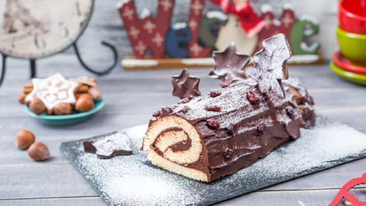 Cakes Bush de Noel Christmas Log home kitchen on New Year decorated wooden background